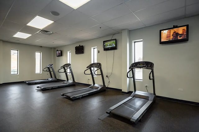 Treadmills lined up with wall mounted televisions gym at Mountain Valley Apartments in Morgantown Student Accommodation