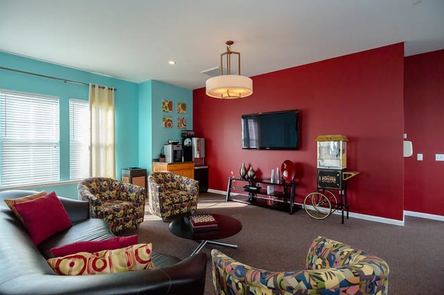 Sofa chairs coffee table TV popcorn machine living room at Mountain Valley Apartments in Morgantown Student Accommodation