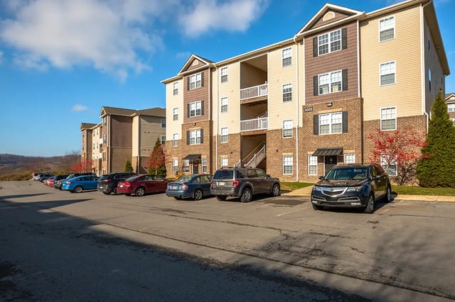 Apartment buildings cars parked in lot exterior at Mountain Valley Apartments in Morgantown Student Accommodation