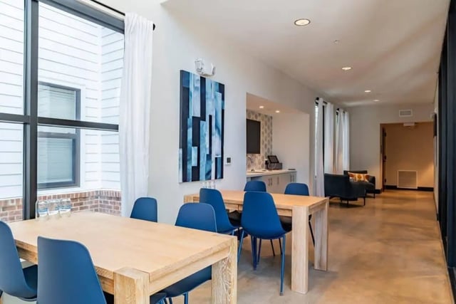 Dining tables with blue chairs kitchen area living area lounge at The Edition on Rosemary in Chapel Hill Student Accommodation