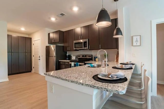 Modern kitchen with granite island and dark cabinets kitchen at The Edition on Rosemary in Chapel Hill Student Accommodation