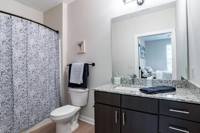 Toilet shower curtain vanity sink countertop bathroom at The Edition on Rosemary in Chapel Hill Student Accommodation