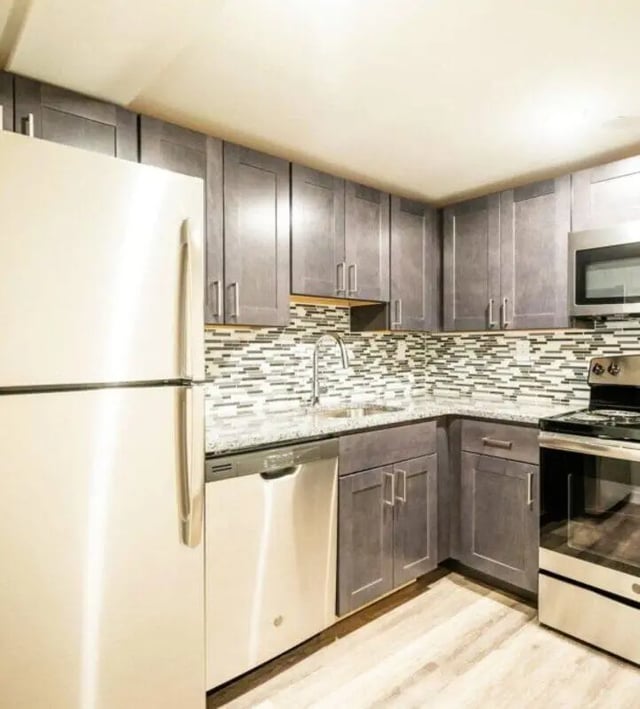 Stainless steel appliances modern cabinets mosaic tile backsplash kitchen at The Eleanor at Chestnut Apartments in Philadelphia Student Accommodation