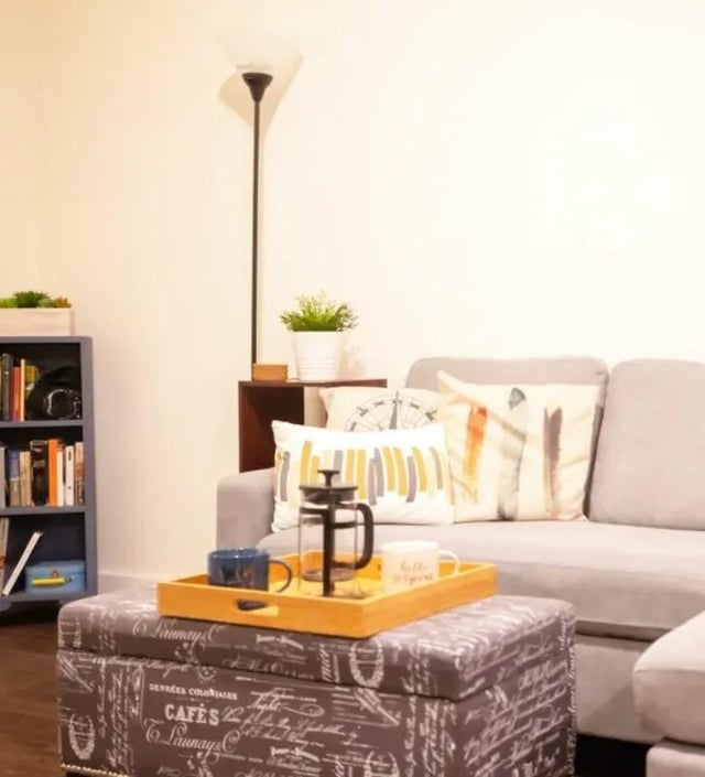 Gray sofa bookshelf ottoman tray with coffee living room at The Eleanor at Chestnut Apartments in Philadelphia Student Accommodation