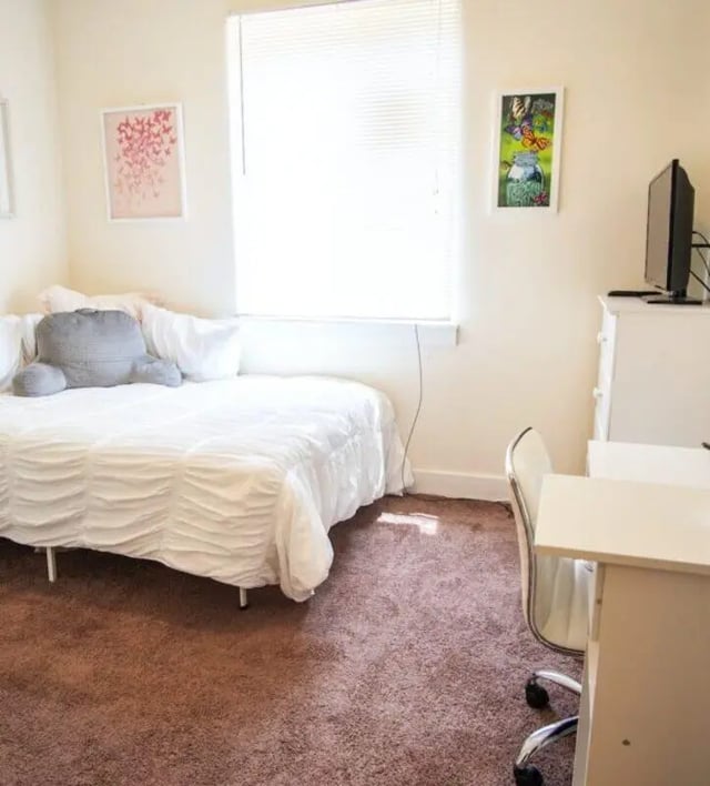Bed with pillows dresser TV desk chair bedroom at The Eleanor at Chestnut Apartments in Philadelphia Student Accommodation