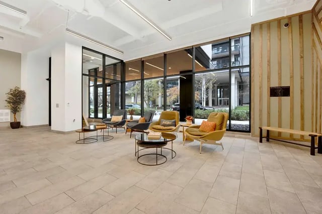 Seating and tables in a bright lobby area at Post Chicago Apartments in Chicago Student Accommodation