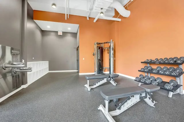 Dumbbells weight machine benches gym area at Post Chicago Apartments in Chicago Student Accommodation