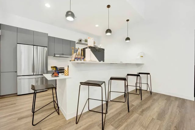 Modern kitchen with stainless steel fridge and bar stools kitchen at Post Chicago Apartments in Chicago Student Accommodation
