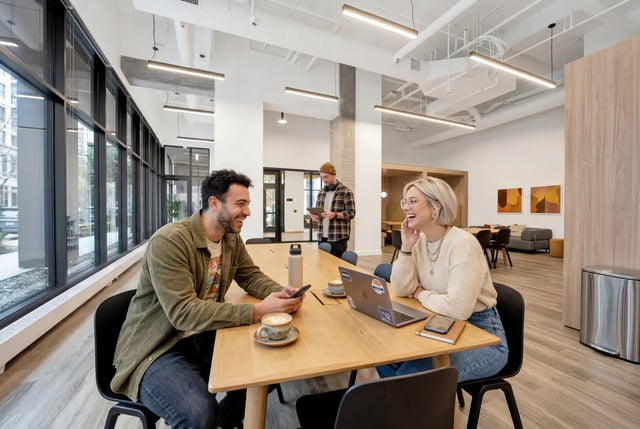 Students at table with laptops coffee and phones study area at Post Chicago Apartments in Chicago Student Accommodation