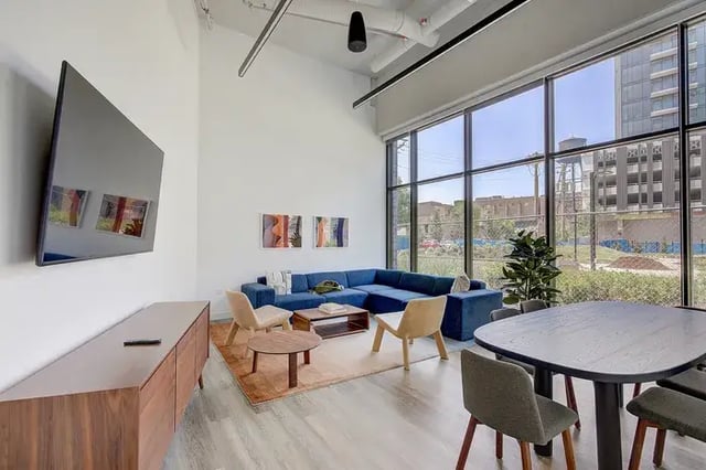 Blue sectional couch coffee table chairs living area at Post Chicago Apartments in Chicago Student Accommodation