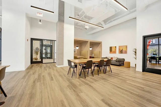Dining table with chairs seating booths and sofa common area at Post Chicago Apartments in Chicago Student Accommodation