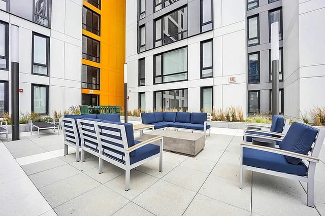 Blue upholstered furniture concrete table outdoor lounge area at Post Chicago Apartments in Chicago Student Accommodation