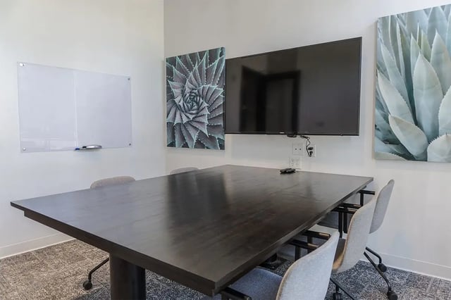 Dark table four chairs whiteboard television art common room at Shortbread Lofts in Chapel Hill Student Accommodation