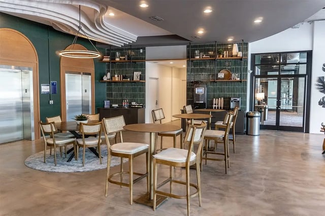 Round tables chairs coffee station elevators common area at Shortbread Lofts in Chapel Hill Student Accommodation