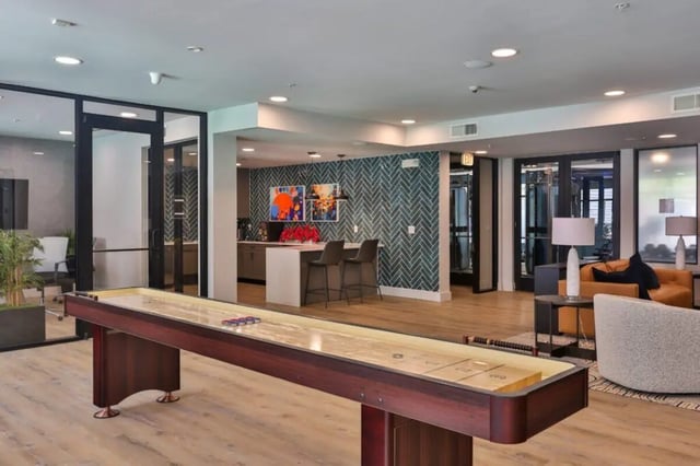 Shuffleboard bar area with seating and living room. at Maverick Place Apartments in Arlington Student Accommodation