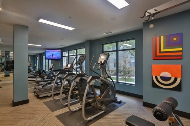 Treadmills ellipticals TV artwork gym fitness area at Maverick Place Apartments in Arlington Student Accommodation