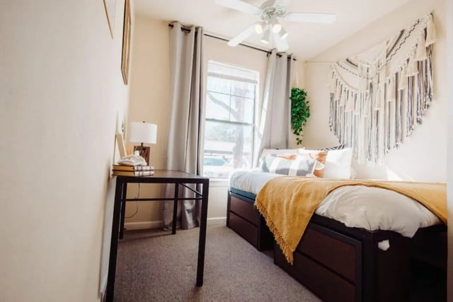 Bed with drawers desk lamp and macrame wall hanging bedroom at Maverick Place Apartments in Arlington Student Accommodation