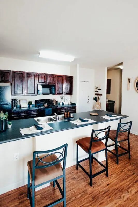 Dark cabinets sink and bar stools kitchen at Maverick Place Apartments in Arlington Student Accommodation