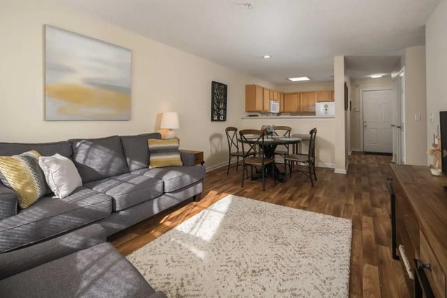 Gray sectional couch dining table and kitchen living room at Mountaineer Village in Boone Student Accommodation