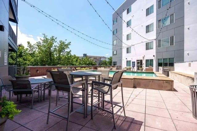 Outdoor seating area with pool and building exterior at Venue On Guadalupe in Austin Student Accommodation