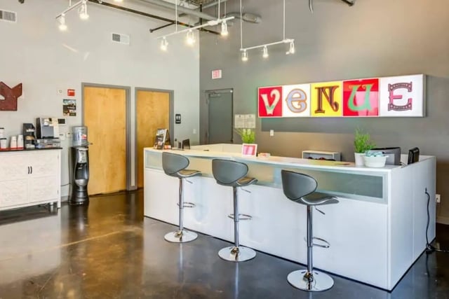 Three bar stools at white reception desk entryway at Venue On Guadalupe in Austin Student Accommodation