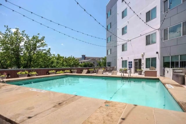 Swimming pool with lounge chairs and building exterior area at Venue On Guadalupe in Austin Student Accommodation