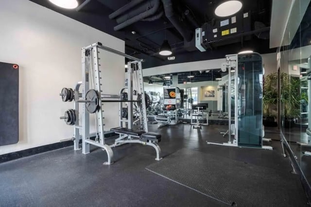 Gym equipment with weights and bench gym area at Venue On Guadalupe in Austin Student Accommodation