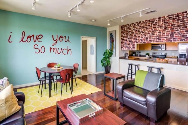Dining table and chairs with kitchen and living area living room at Venue On Guadalupe in Austin Student Accommodation