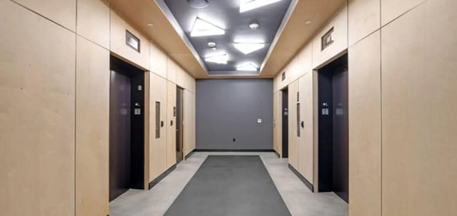 Hallway with elevators and wood paneling hallway at Parc View at Commonwealth in Richmond Student Accommodation