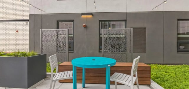Turquoise table two chairs wooden bench patio area exterior at Parc View at Commonwealth in Richmond Student Accommodation