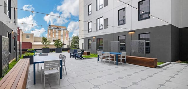 Courtyard tables chairs benches with string lights exterior at Parc View at Commonwealth in Richmond Student Accommodation