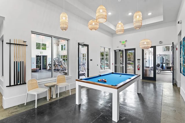 Pool table billiard cues chairs and gym visible recreation area at Venue at North Campus in Tampa Student Accommodation