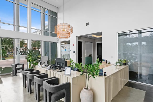 Reception desk with chairs and plants interior at Venue at North Campus in Tampa Student Accommodation