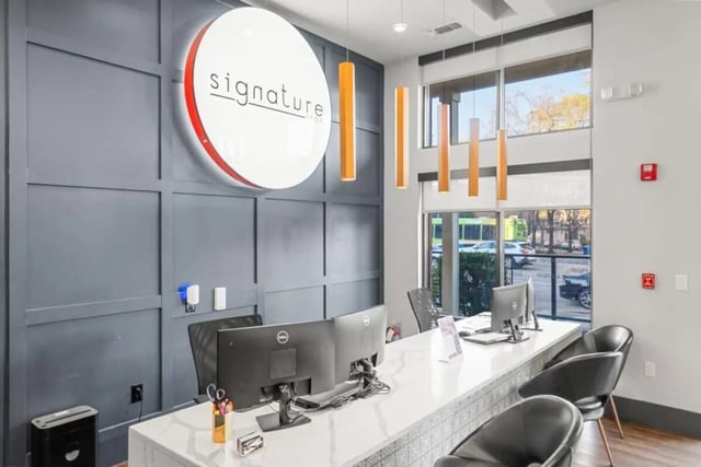 Signature sign computers chairs reception desk exterior at Signature 1505 in Raleigh Student Accommodation