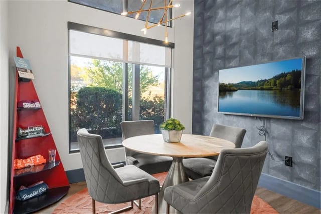 Round table four chairs television and red display living room at Signature 1505 in Raleigh Student Accommodation