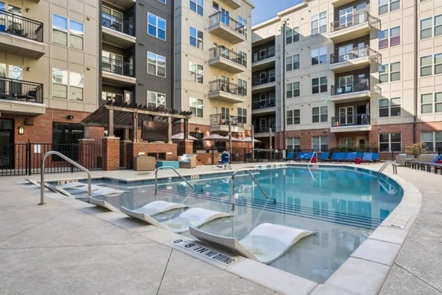Swimming pool with lounge chairs and building exterior at Signature 1505 in Raleigh Student Accommodation