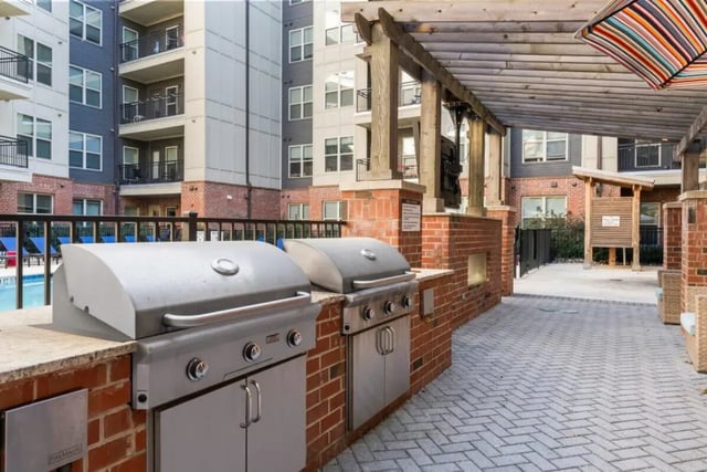 Two grills by pool on brick patio exterior at Signature 1505 in Raleigh Student Accommodation