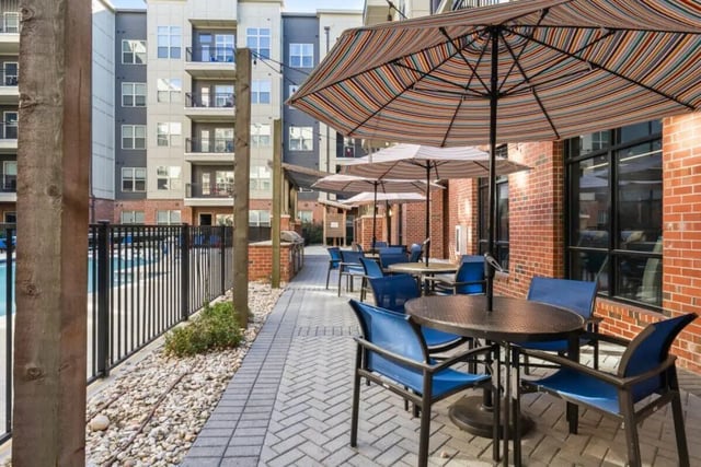 Outdoor seating area with tables umbrellas and chairs exterior at Signature 1505 in Raleigh Student Accommodation