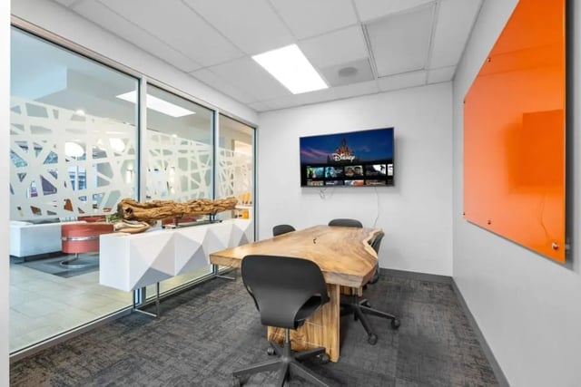 Live edge table chairs TV and orange board meeting room at Signature 1909 in Austin Student Accommodation
