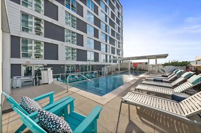 Deck chairs by pool lounge chairs exterior at Signature 1909 in Austin Student Accommodation