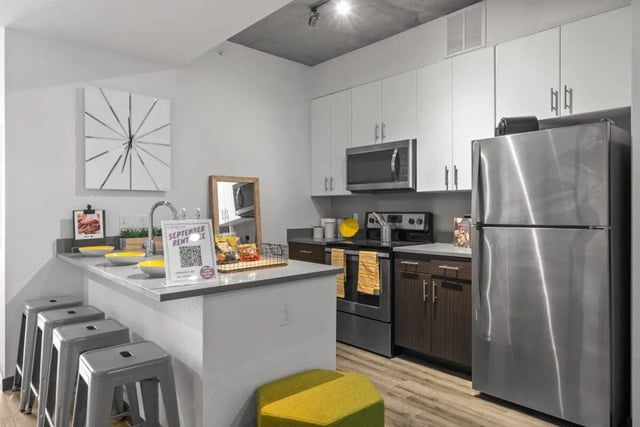 Modern kitchen with stainless steel appliances and bar stools kitchen at Signature 1909 in Austin Student Accommodation