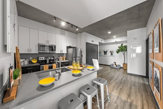 Modern kitchen with island and seating living area at Signature 1909 in Austin Student Accommodation