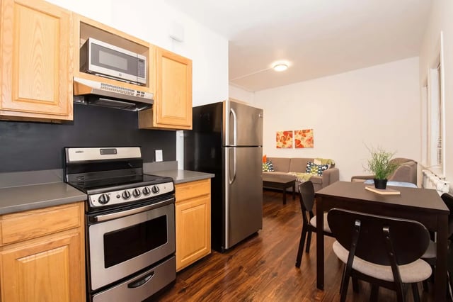 Kitchen with stainless steel appliances and living room living room at Hamilton Court in Philadelphia Student Accommodation