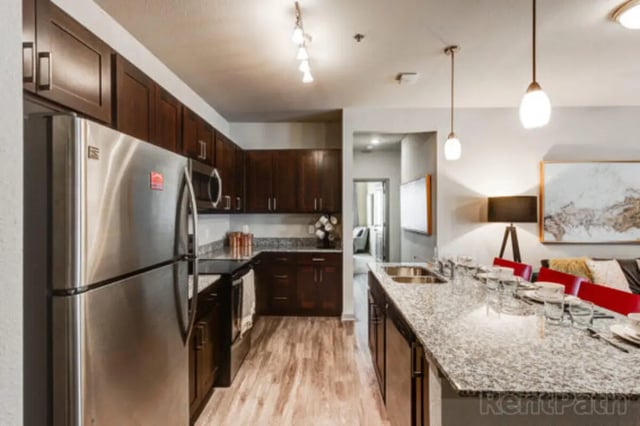 Stainless refrigerator dark cabinets granite island kitchen at Stadium View in Bozeman Student Accommodation