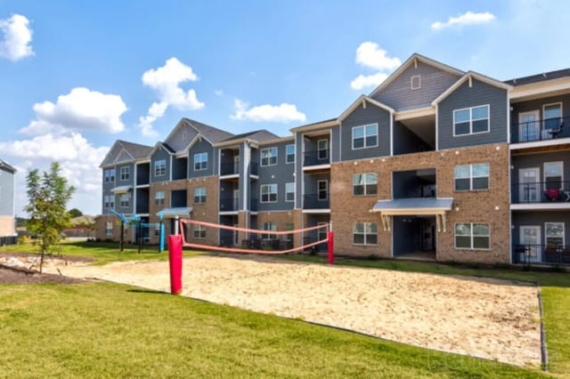 Volleyball court in front of apartment building exterior at Stadium View in Bozeman Student Accommodation