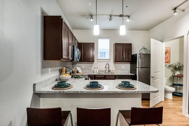 Kitchen counter with bar stools and cabinets kitchen at Hannah Townhomes & Lofts in East Lansing Student Accommodation