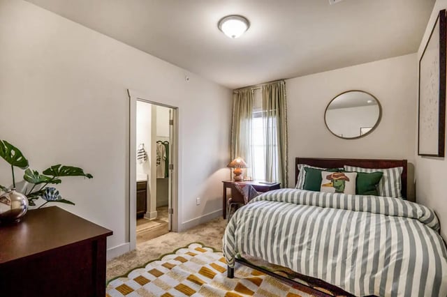 Bed with striped comforter and desk bedroom at Hannah Townhomes & Lofts in East Lansing Student Accommodation