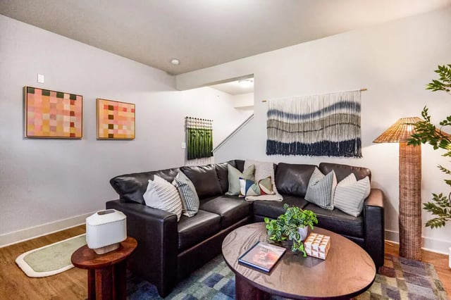 Leather sectional coffee table wall art living room at Hannah Townhomes & Lofts in East Lansing Student Accommodation