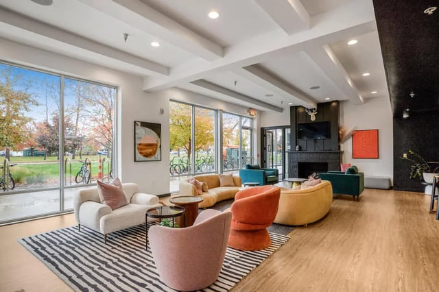Colorful sofas fireplace television and art living room at Hannah Townhomes & Lofts in East Lansing Student Accommodation