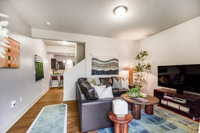 Dark leather couch, coffee table, television living room at Hannah Townhomes & Lofts in East Lansing Student Accommodation